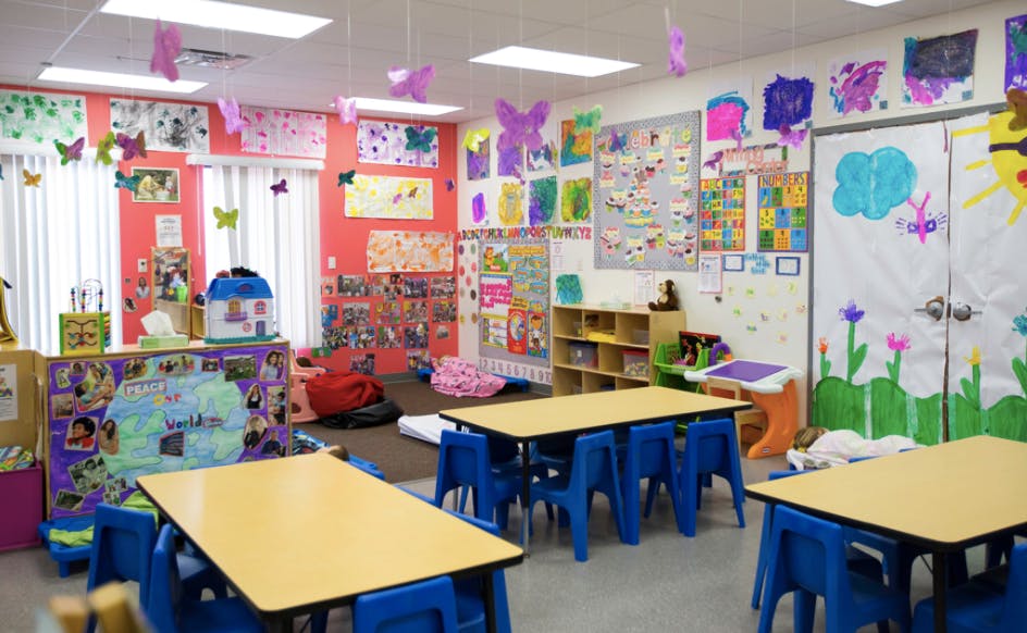 Classroom with small tables and chairs, decorated walls