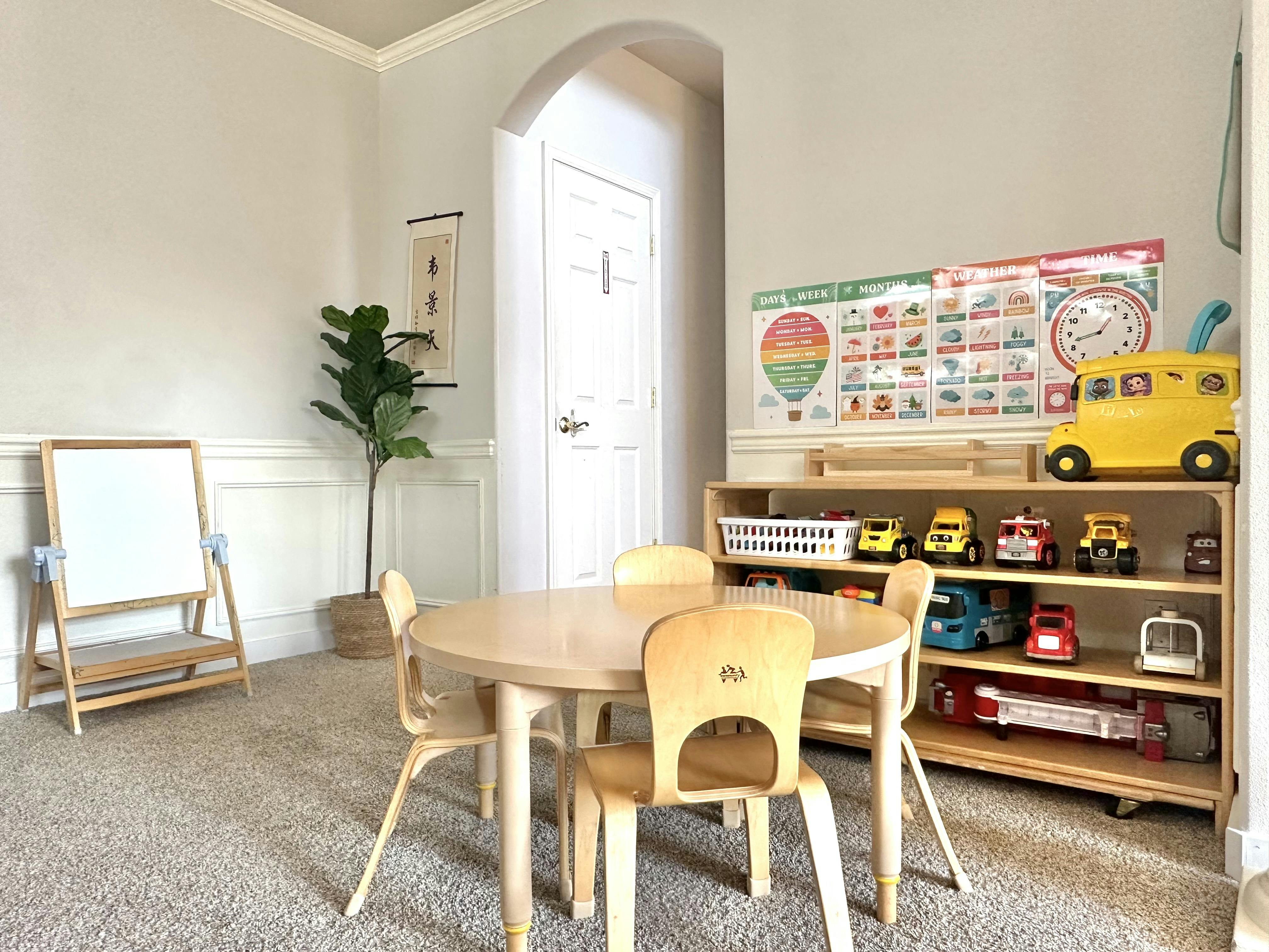 Small round table and chairs in a children playroom with toy storage