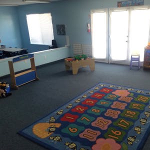 empty classroom with number rug and small tables