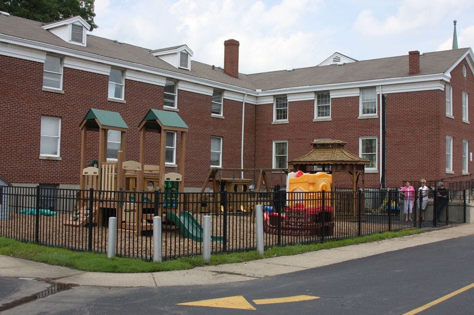 Brick building with a fenced playground in front