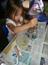 Child painting at a table covered with newspaper
